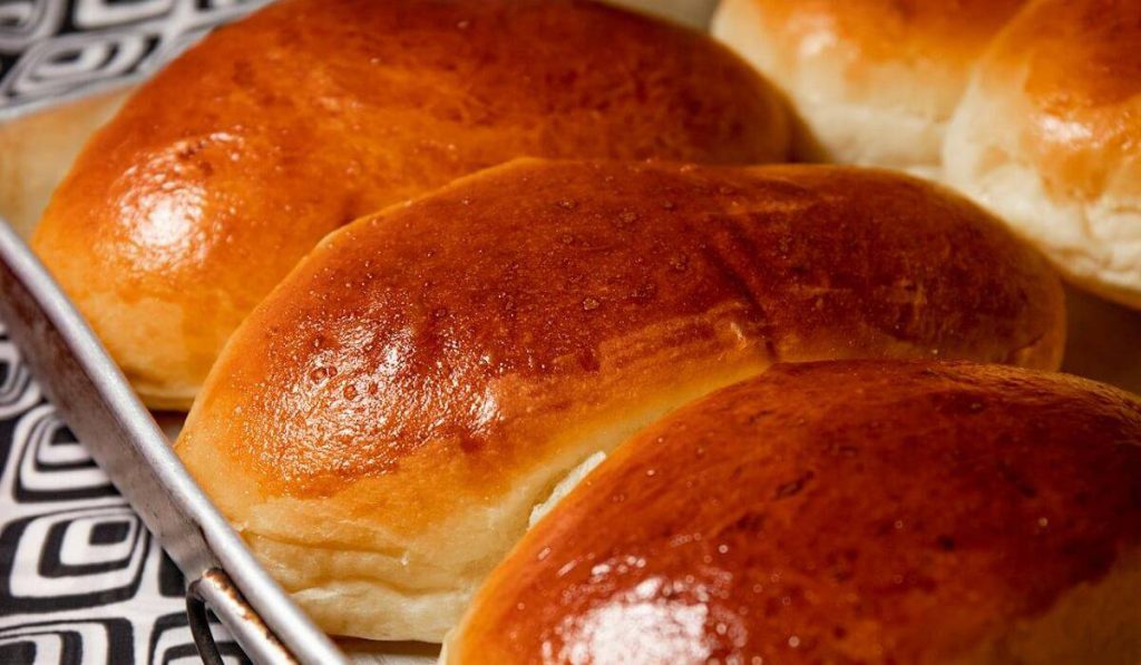 A freshly baked breads on a stainless tray.
