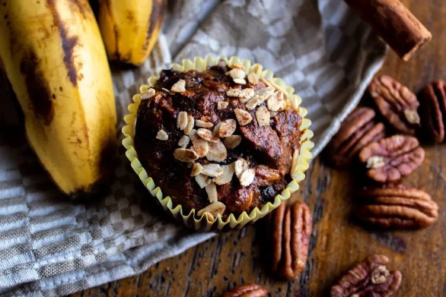 Sourdough banana muffins on a wooden table with a banana decoration