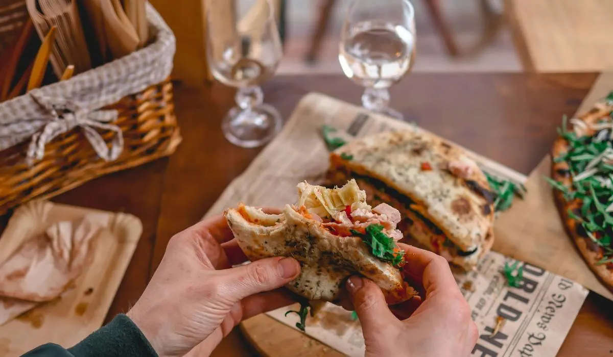 Man holding a Gyros with Pita Bread in a restaurant.