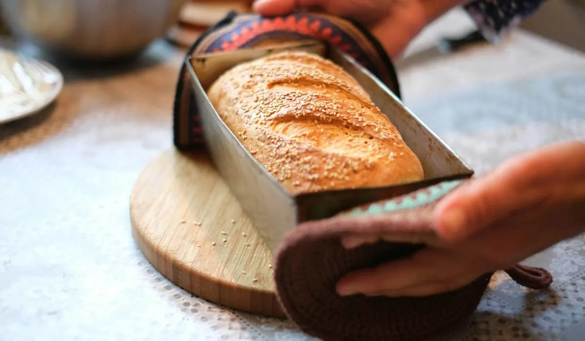 Holding homemade bread leaving on a wooden plate