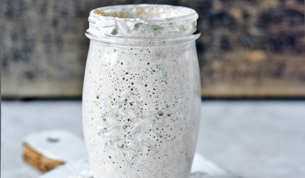 clear glass jar with sourdough starter on white wooden table