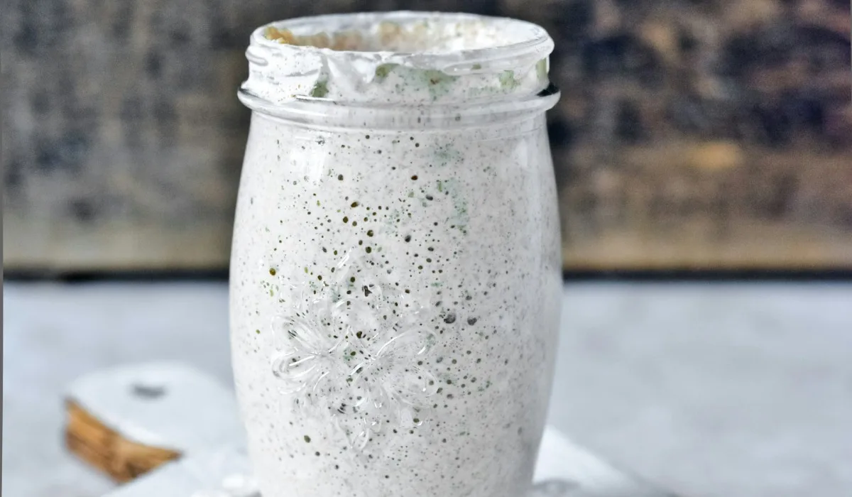 clear glass jar with sourdough starter on white wooden table