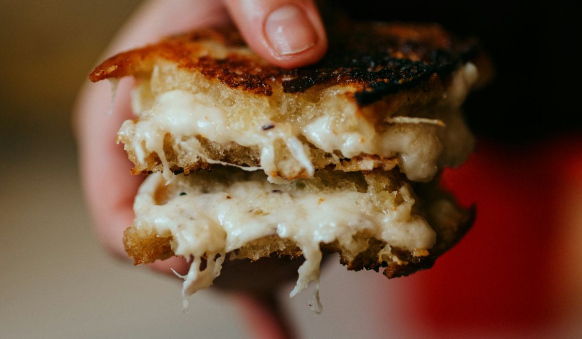 Sourdough grilled cheese holding in hands
