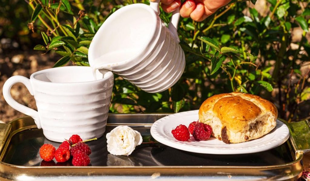 English breakfast with milk and cross buns served on a tray