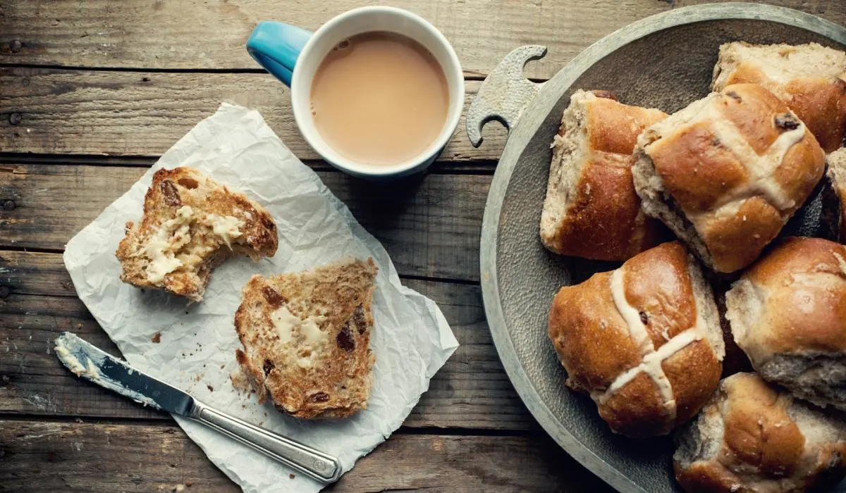 A breakfast with hot cross buns and a glass of milk